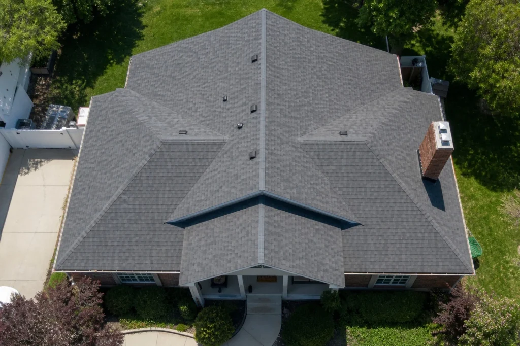 Overhead view of a well maintained residential roof with clean gutters and chimney